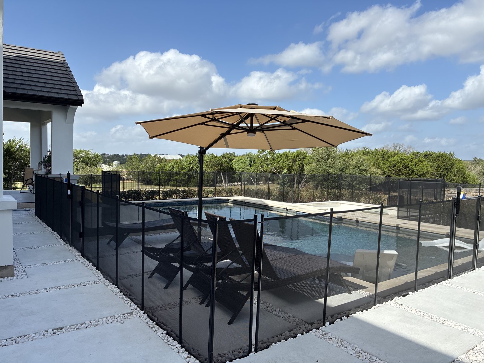 Removable mesh pool fence enclosing a pool and spa on a Hill Country estate in the Belvedere neighborhood near Bee Cave TX, All-Safe certified
