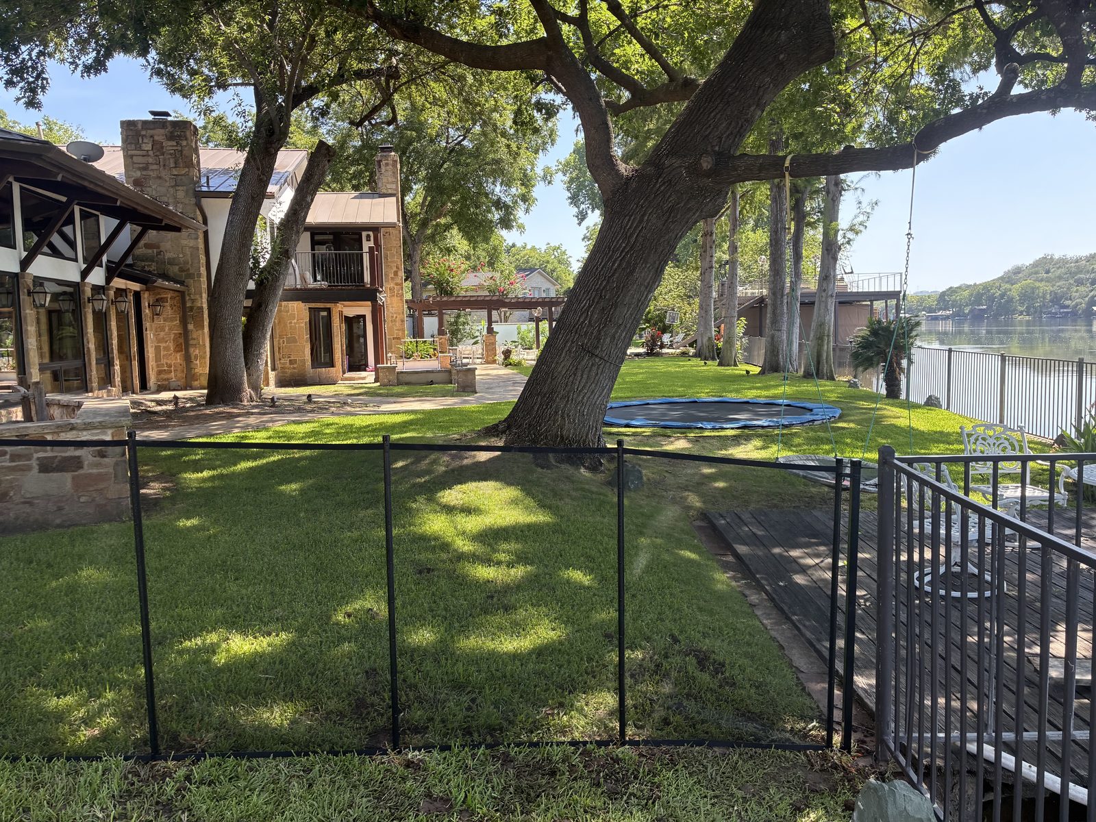 Removable mesh safety fence separating the lawn from the Lake Austin waterfront at a Westlake home in Austin TX, All-Safe certified