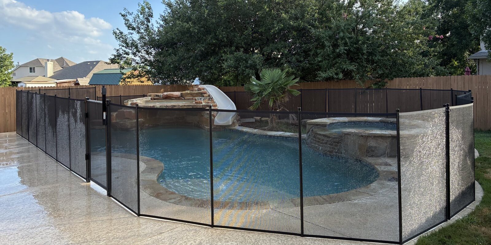 Removable mesh pool fence with reinforced aluminum poles installed around a backyard pool in the Austin area, All-Safe certified