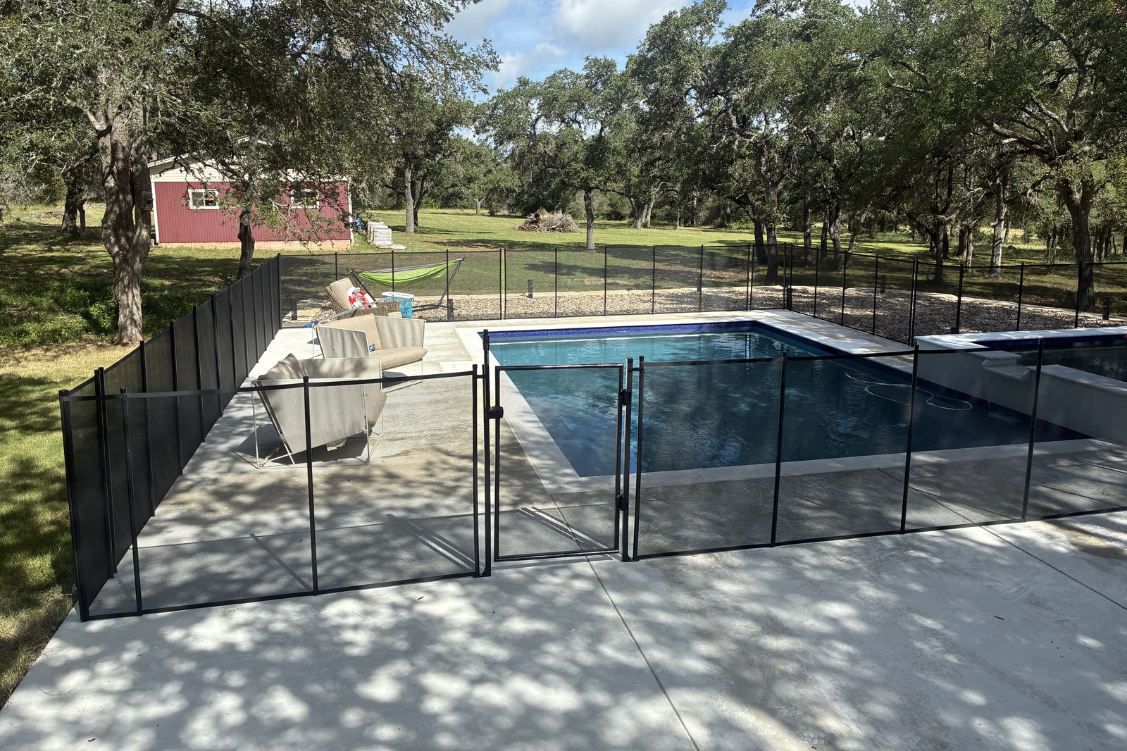 Removable mesh pool fence with self-closing safety gate around a pool in San Marcos TX, All-Safe certified